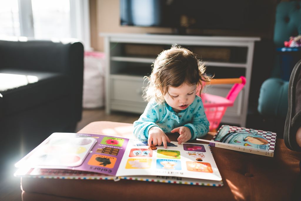 criança com livro de atividades de educação infantil